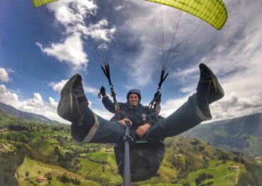 Tourist enjoying a Medellin Paragliding Tour with panoramic views of the Aburrá Valley and surrounding mountains