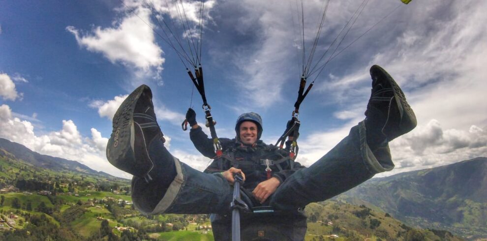 Tourist enjoying a Medellin Paragliding Tour with panoramic views of the Aburrá Valley and surrounding mountains