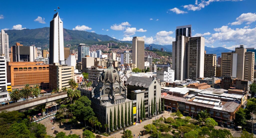Medellin City Tour & Comuna 13 visitors exploring colorful graffiti murals and outdoor escalators with local guide.