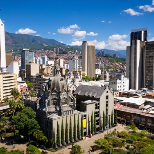 Medellin City Tour & Comuna 13 visitors exploring colorful graffiti murals and outdoor escalators with local guide.