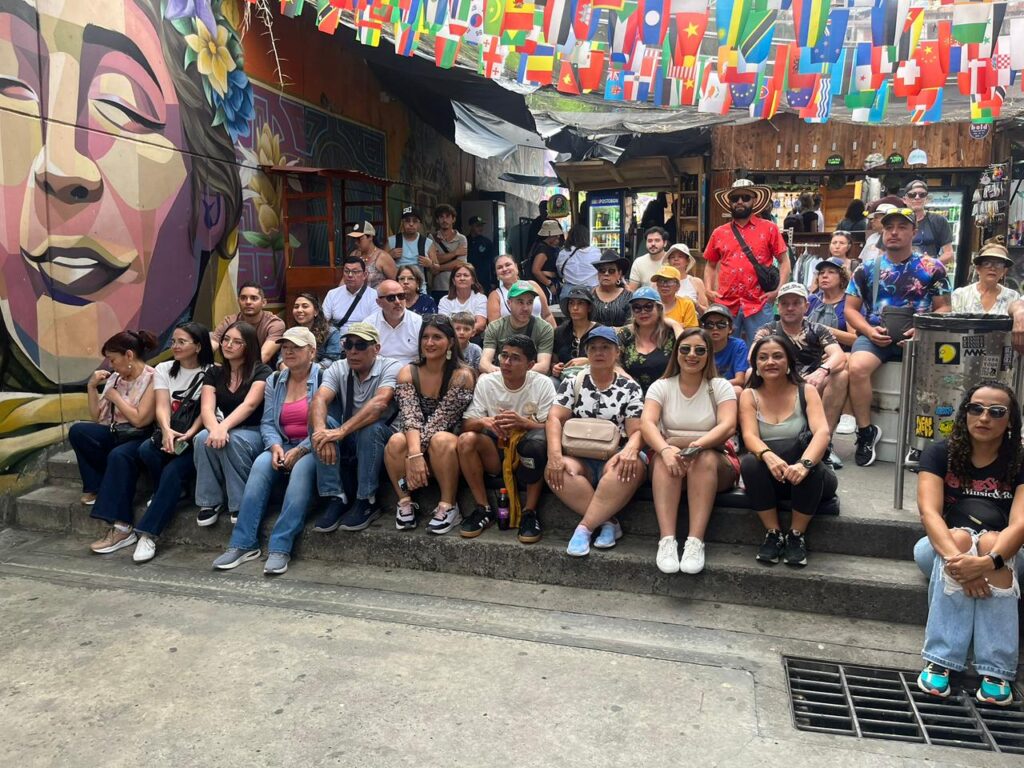 Travelers exploring colorful graffiti murals and outdoor escalators during a Private Comuna 13 Tour Medellin with a local guide.